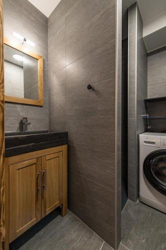 une salle de bain avec un lavabo et une machine à laver dans l'établissement Appartement neuf avec terrasse plein sud - 6 personnes, à Saint-Sorlin-dʼArves
