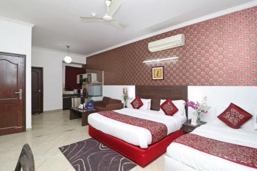 a hotel room with two beds and a living room at Hotel Jashn Inn near Apollo Hospital in New Delhi