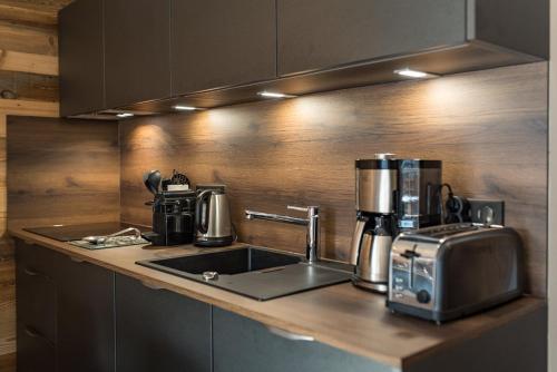 a kitchen with a sink and a coffee maker on a counter at Appartement neuf avec terrasse de 50m2 plein sud - 6 personnes in Saint-Sorlin-dʼArves