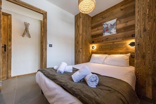 a bedroom with a large bed with towels on it at Appartement neuf avec terrasse de 50m2 plein sud - 6 personnes in Saint-Sorlin-dʼArves