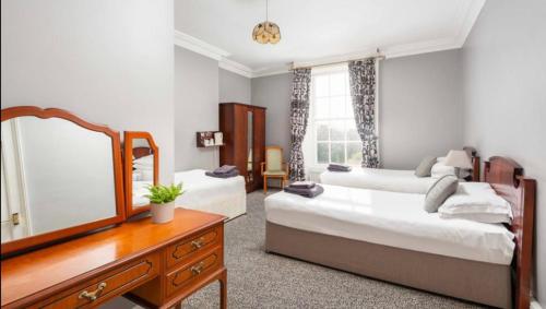 um quarto com 2 camas, uma cómoda e um espelho em Abbeyleigh House em Dublin