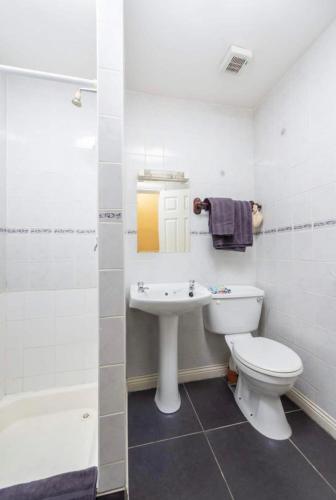 uma casa de banho com um WC branco e um lavatório. em Abbeyleigh House em Dublin