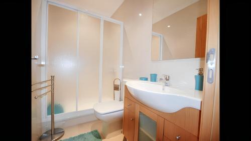 Baño blanco con lavabo y aseo en 2 bedrooms house with shared pool terrace and wifi at Albufeira, en Albufeira