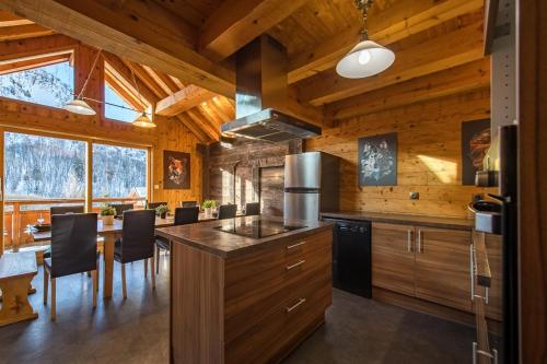 a kitchen with wooden walls and a table and chairs at Chalet de charme 11 personnes proche du centre du village in Saint-Sorlin-dʼArves