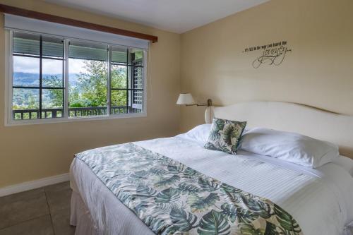 een slaapkamer met een bed en een raam bij Coffee Estate Inn in Boquete