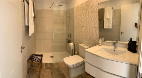 a white bathroom with a toilet and a sink at Alecu Home in Puerto del Carmen