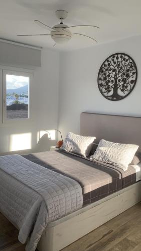 a bedroom with a large bed with a ceiling fan at Alecu Home in Puerto del Carmen