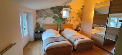 PompignanにあるLa Bastide de Sigalasのベッドが2つあり、壁に絵が飾られた寝室