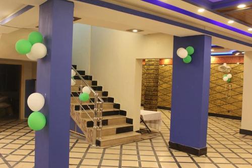a room with a staircase with green and white balloons at Kashmir Inn Hotel in Muzaffarabad