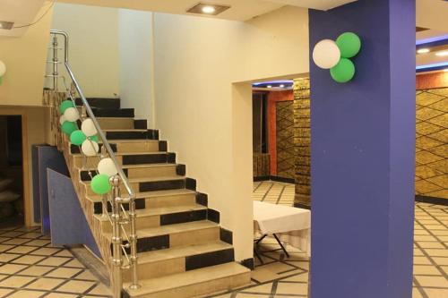 a set of stairs with green and white balloons at Kashmir Inn Hotel in Muzaffarabad