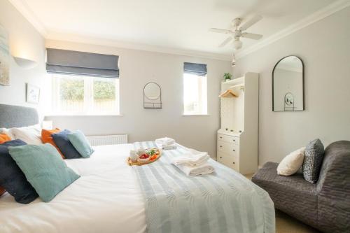 Aldringhamにある1 Hazelwood, Aldeburghのベッドルーム(大きな白いベッド1台、ソファ付)
