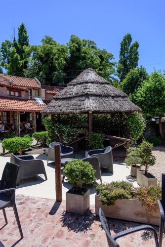 a patio with chairs and a straw umbrella at Curahue Apart Hotel in Tandil