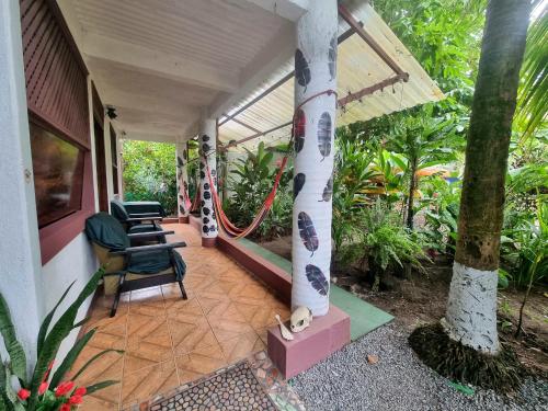 a porch of a house with chairs and plants at Wildlife Tortuguero in Tortuguero