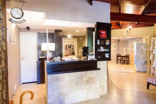 a kitchen with a counter with a clock on the wall at Curahue Apart Hotel in Tandil