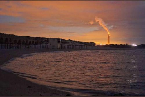 a view of the beach with a factory in the background at Czarina Cabin הבקתה הקיסרית והדירה הקיסרית czarina apartment in Caesarea
