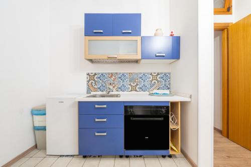 a kitchen with blue cabinets and a black dishwasher at Alla Marina Cagliari in Cagliari