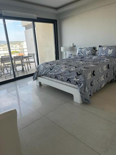 une chambre avec un lit et un balcon avec une table dans l'établissement cannes seaview penthouse, à Cannes