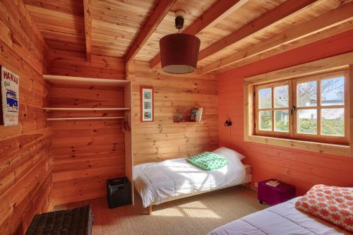 1 dormitorio en una cabaña de madera con 2 camas en Paisible et insolite chalet pour 4 personnes a Penmarch en Penmarcʼh