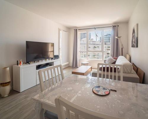 een woonkamer met een tafel en een woonkamer met een bank bij Skyview appartement la Défense in Courbevoie