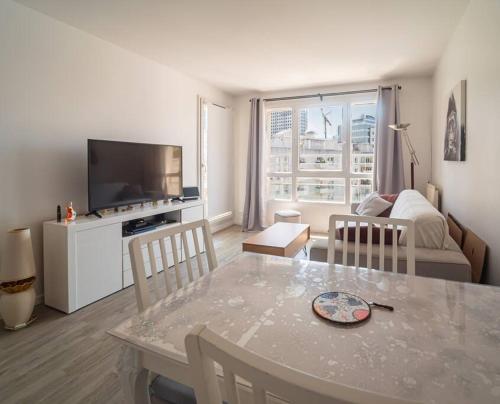 - un salon avec une table et un canapé dans l'établissement Skyview appartement la Défense, à Courbevoie