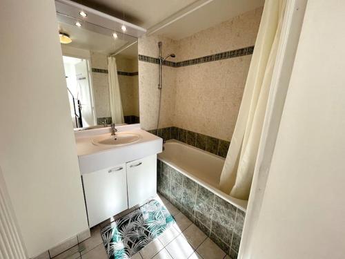 une salle de bain avec un lavabo et une baignoire dans l'établissement Skyview appartement la Défense, à Courbevoie