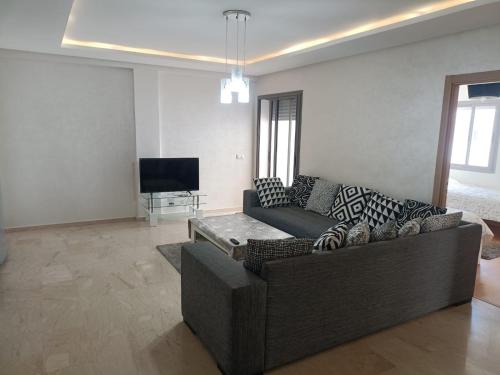 sala de estar con sofá y TV en Appartement au Parc Mohammedia, en Mohammedia