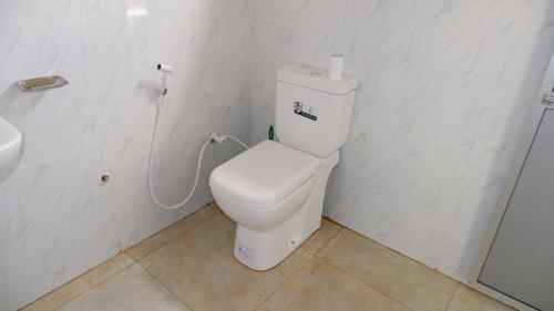 uma casa de banho branca com um WC e um lavatório em Attale Resort em Hambantota