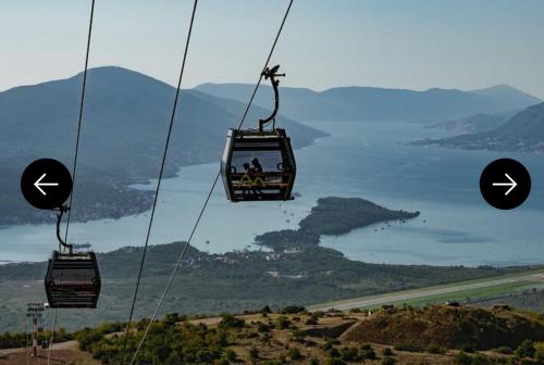 a gondola with two people on it flying over a mountain at Casa del Sole Lux in Kotor