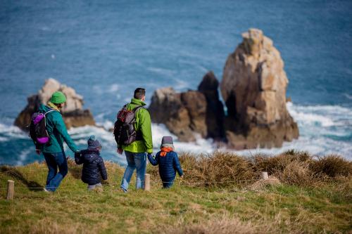 a group of people walking on a hill near the ocean at Hôtel Ginkgo - SPA Biloba in Quimper