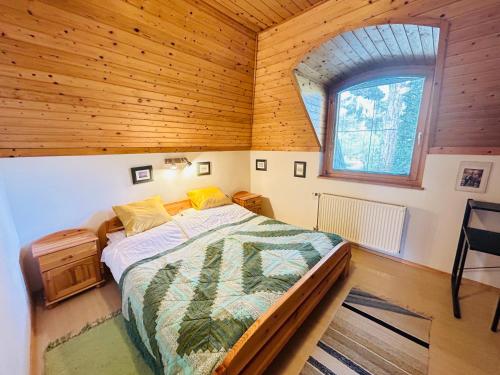 um quarto com uma cama numa casa de madeira em Nefelejts Deluxe Home em Zamárdi