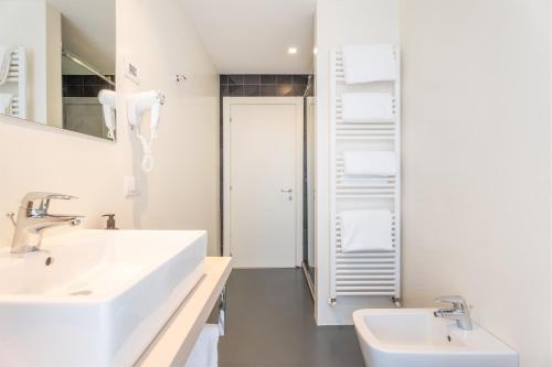 a white bathroom with two sinks and a mirror at On The Rock in Arco