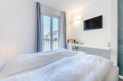 a white bedroom with a bed and a window at On The Rock in Arco