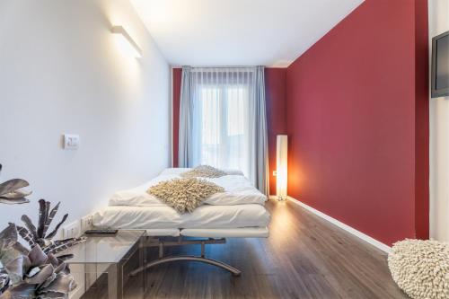 a room with a bed and a red wall at On The Rock in Arco