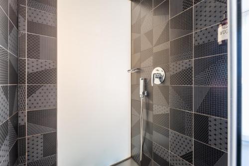 a shower with black and gray tiles in a bathroom at On The Rock in Arco