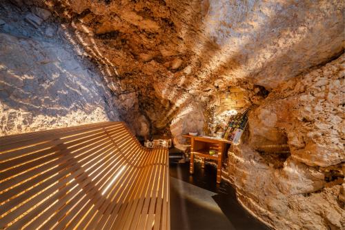 a room in a cave with a wooden floor and stairs at On The Rock in Arco