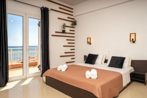 a bedroom with a bed and a view of the ocean at C'est La Vie Rooms and Suites in Laganas