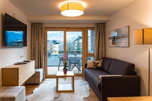 un soggiorno con divano e tavolo di Spa Apartments - Zell am See a Zell am See