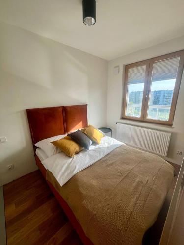 a bedroom with a bed with two pillows on it at Tutu Kraków Comfort in Krakow