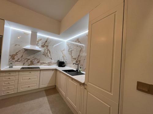 a white kitchen with marble walls and a door at Best loft luxury in Madrid center 12 in Madrid