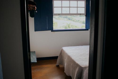 Cette chambre comprend une fenêtre et une table. dans l'établissement Recanto do Inconfidente, à Resende Costa