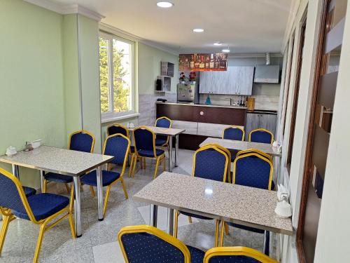 una sala con tavoli e sedie e una cucina di Hotel Georgian Memory a Kutaisi