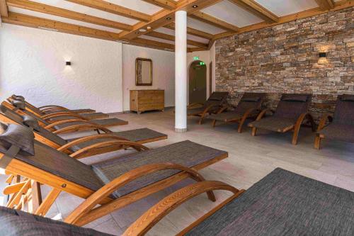 a room with chairs and tables and a brick wall at Spa Apartments - Zell am See in Zell am See