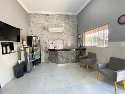 a waiting room with two chairs and a counter at Pousada Itaguaçu in Aparecida