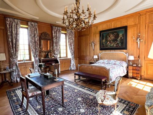 a living room with a bed and a table at Château de La Rivière in Pontgouin
