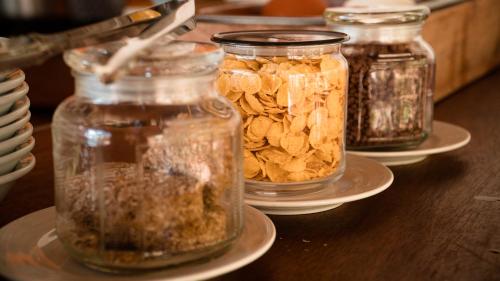 four jars of nuts on plates on a wooden table at Temple Point Resort in Watamu