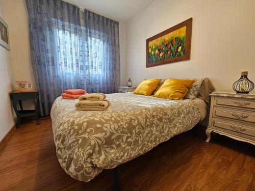 um quarto com uma cama com duas toalhas em Casa Lantoxana 1A121 em Gijón