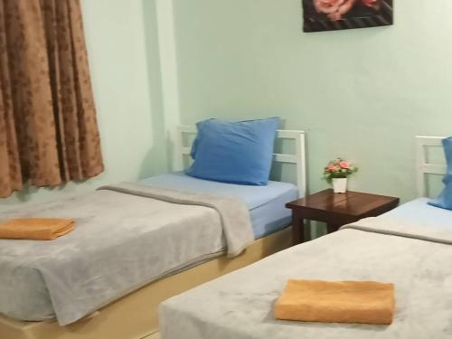 a room with two beds with blue pillows at Anchalee Resort in Bang Saphan