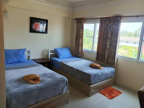 a bedroom with two beds and a window at Anchalee Resort in Bang Saphan