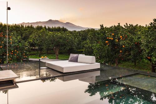 a white couch sitting on top of a glass table at Zash Country Boutique hotel & SPA in Giarre