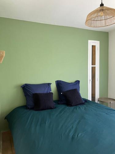 a bedroom with a blue bed with blue pillows at Casa sardine in Cassis
